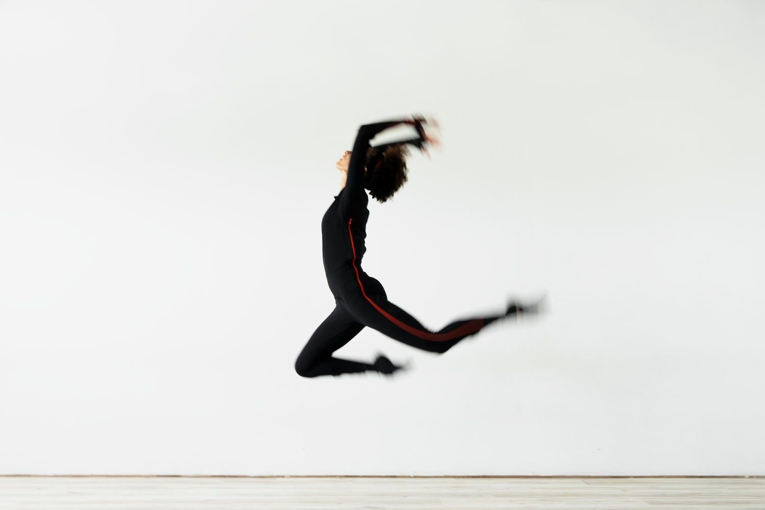 A dancer in a motion capture suit mid-leap
