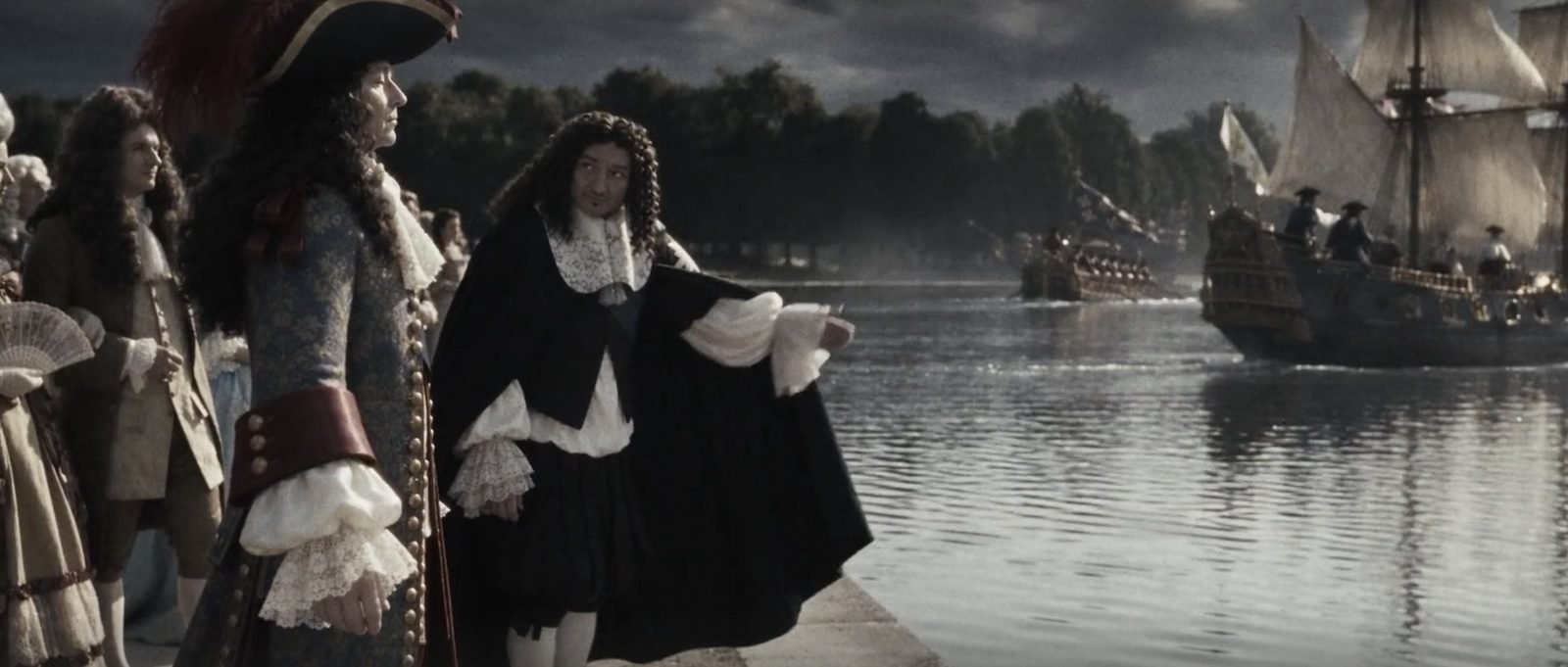 Courtiers in 17th-century dress by a basin, with sailing ships in the background